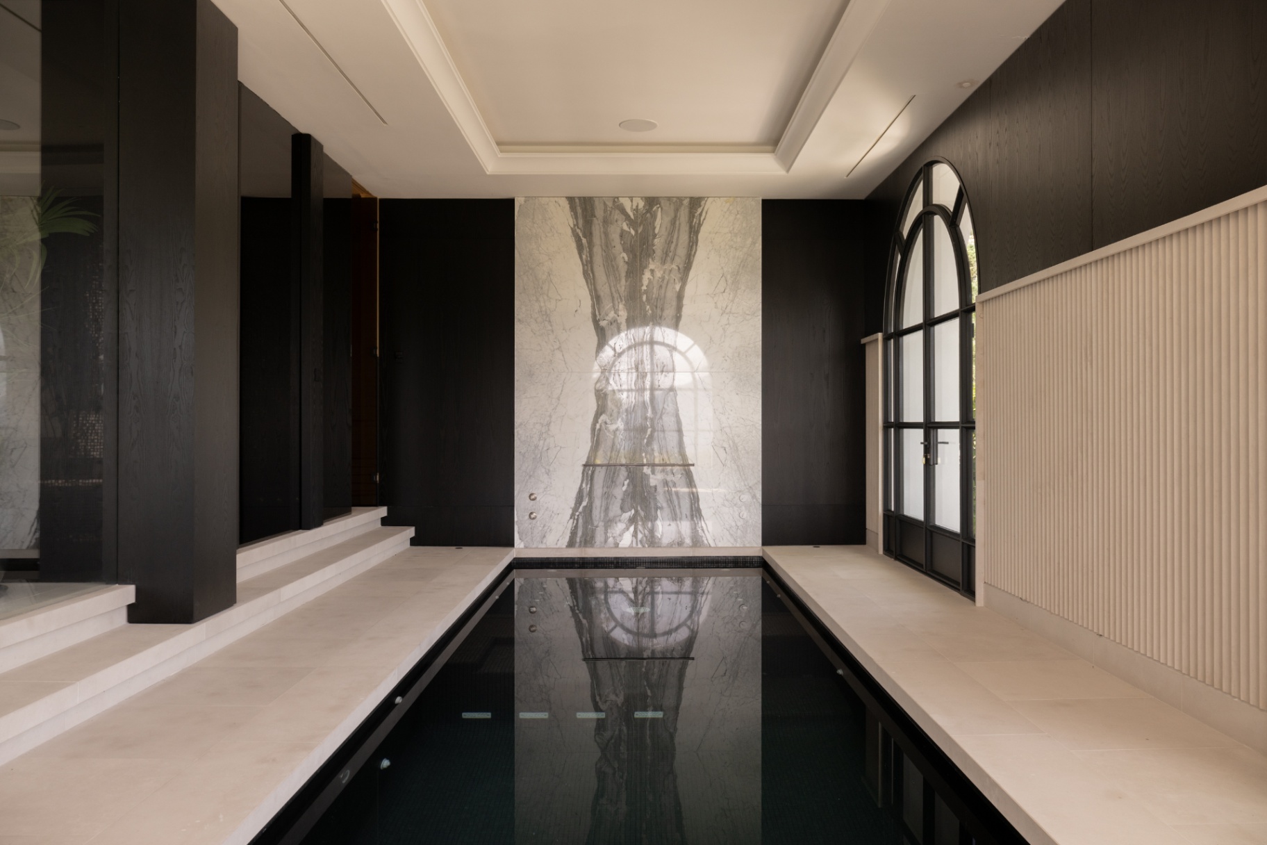 The indoor wellness pool at Casa Servetta with dark timber walls.
