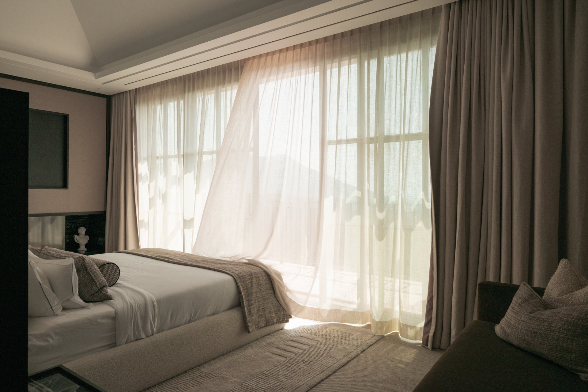 A softly lit bedroom at Casa Servetta with sheer curtains in the breeze.